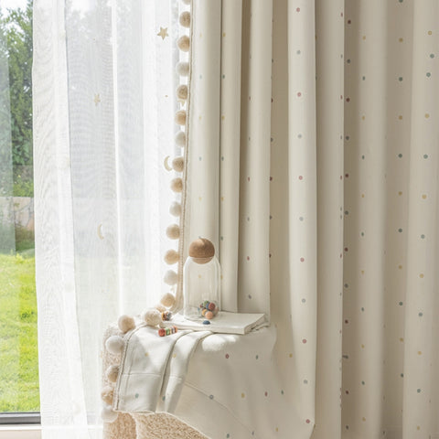 Tende color crema per la cameretta dei bambini con pois pastello e pompon oscuranti