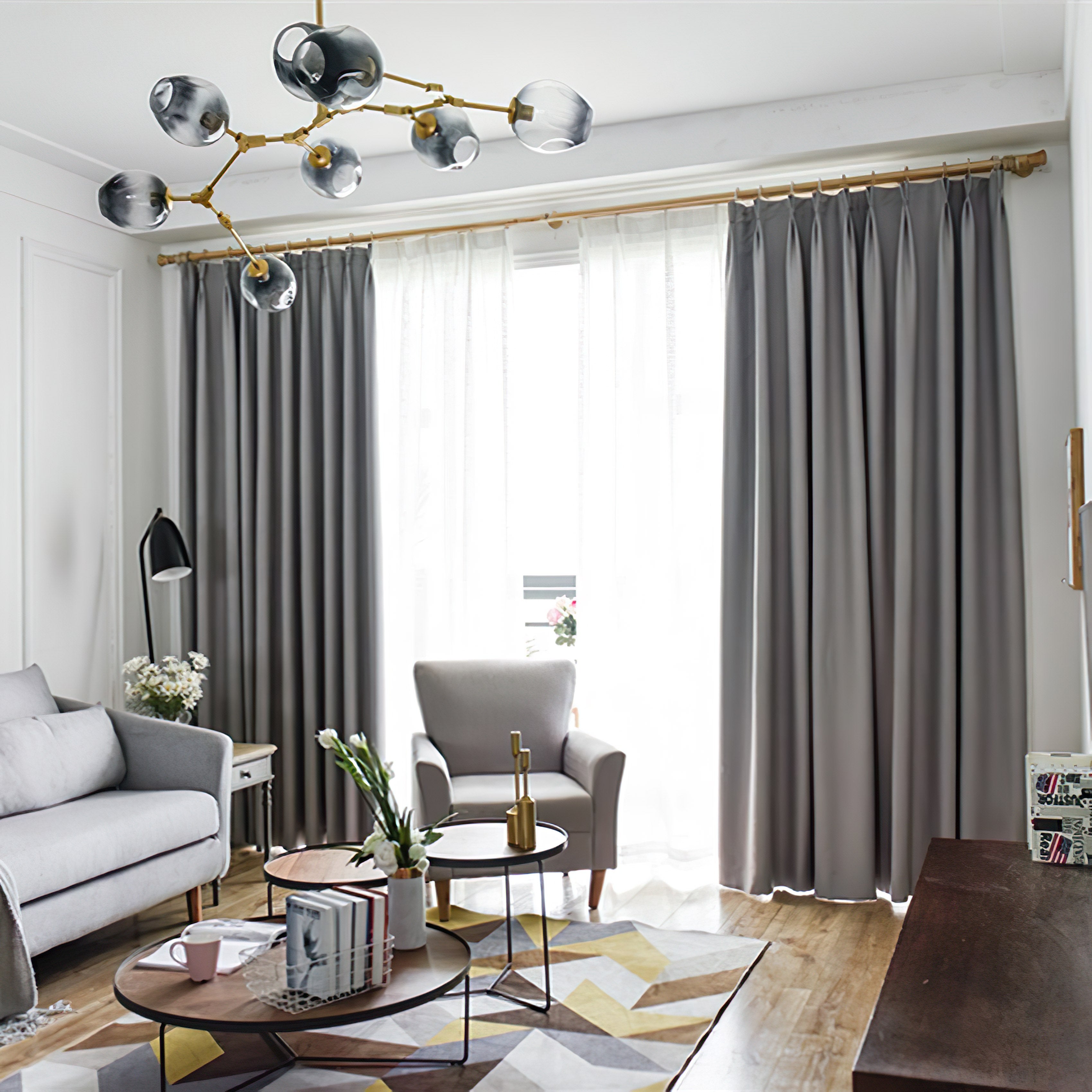 Salon élégant avec rideaux gris encadrant une grande fenêtre