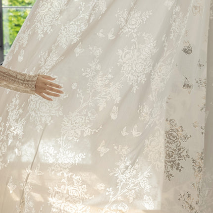 a woman standing in front of a white curtain