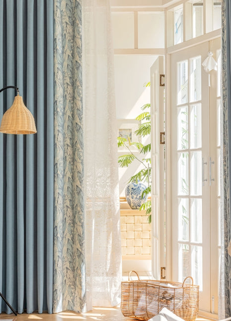 a living room with blue curtains and a white chair