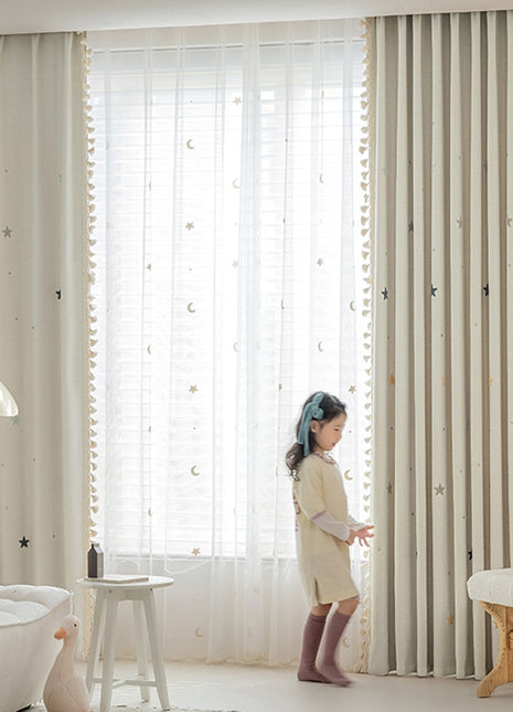 a little girl standing in front of a window