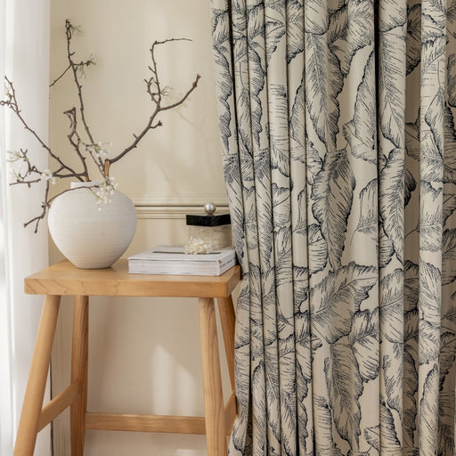 a white vase sitting on top of a wooden table