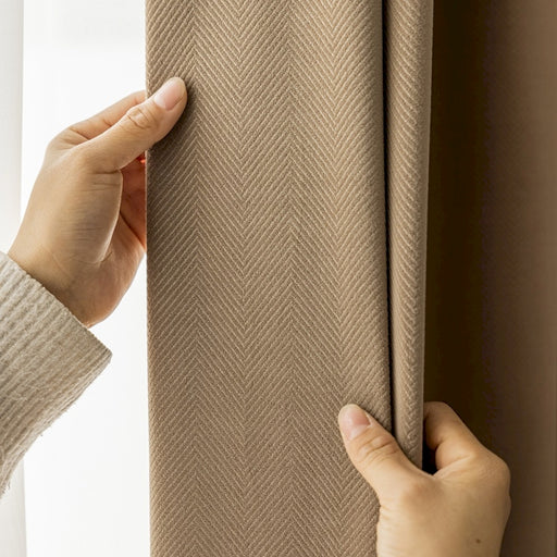 a person holding a curtain with their hand