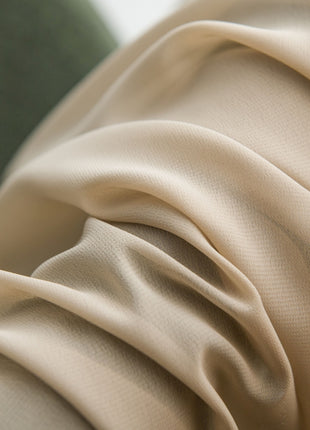 a close up of a fabric with a green chair in the background