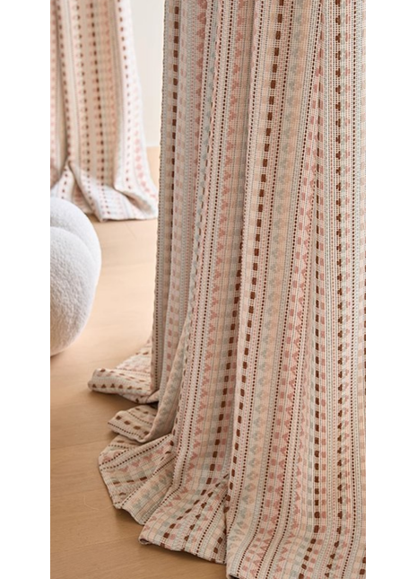 a close-up view of a curtain with a striped pattern in shades of pink and white. The curtain is partially drawn, revealing a wooden floor beneath it.