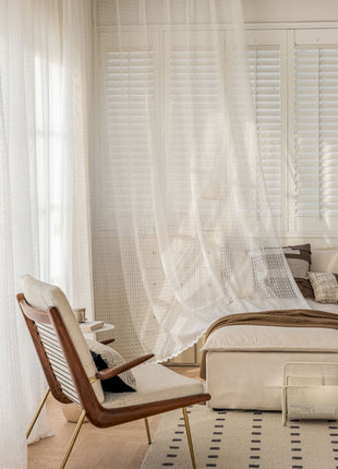 a bedroom with a bed and a chair in it