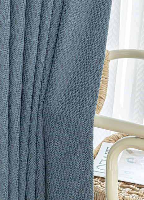 a close up of a curtain with a chair in the background