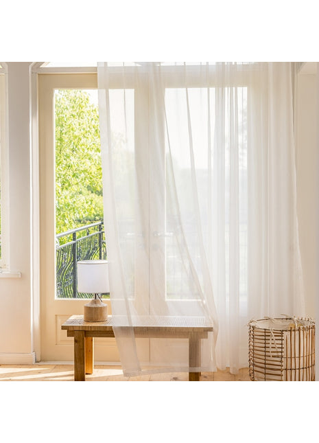 a room with a table and a white curtain