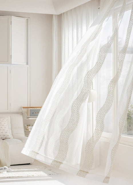 a living room with a white couch and curtains