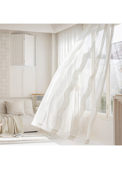 a living room with a white couch and curtains