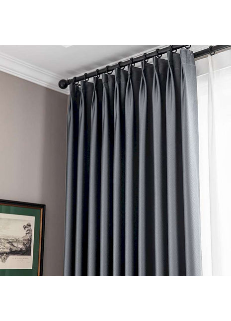 a window with a black curtain and a picture on the wall