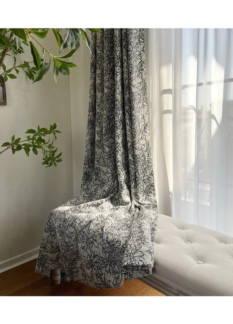 a white couch sitting under a window next to a plant
