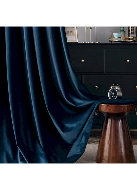 a room with a black dresser and a blue curtain