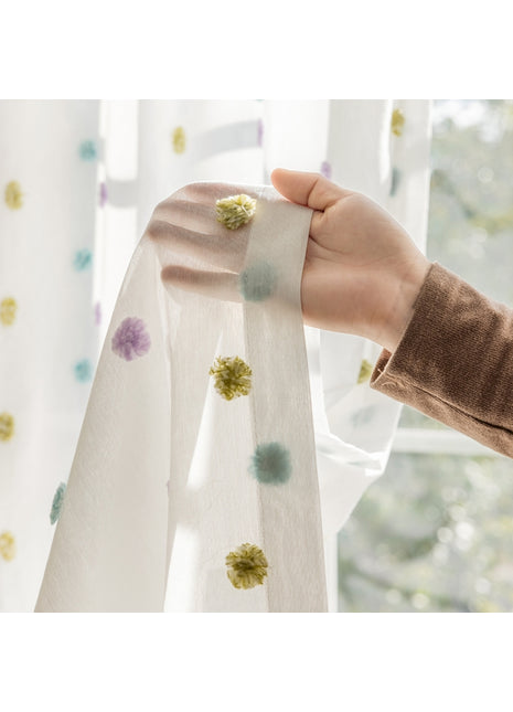 a person holding a curtain with a flower on it