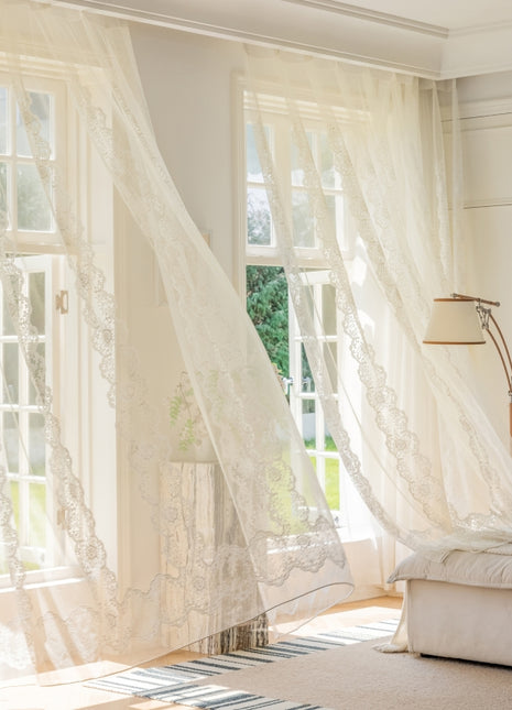 a living room with white curtains and a couch