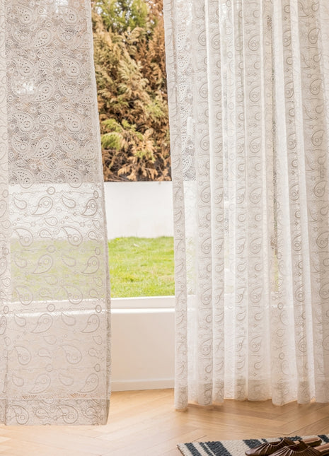 a pair of shoes sitting on a rug in front of a window