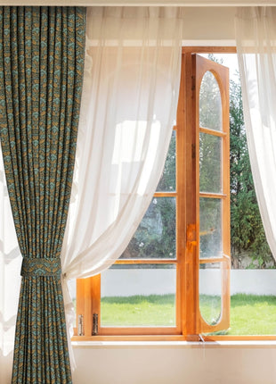 a window with a curtain and a chair in front of it