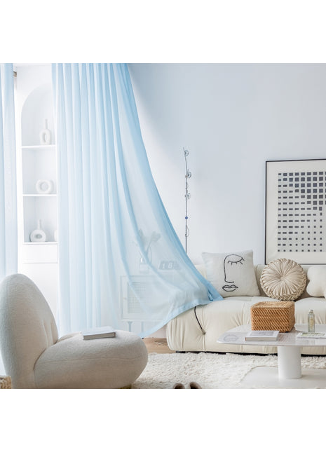 a living room with a white couch and blue drapes