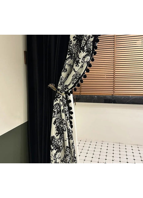 a black and white curtain with pom pom trim
