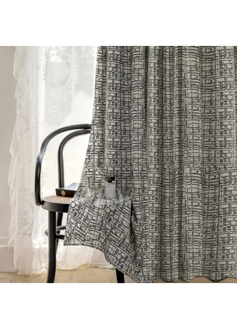 a chair sitting in front of a window next to a curtain