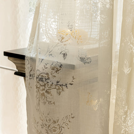 a white curtain with a floral design on it