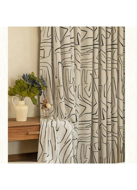 a white bed sitting next to a window covered in curtains