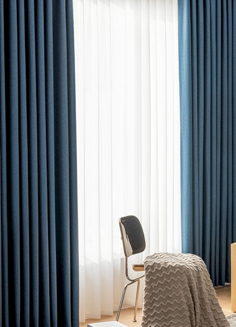 a bedroom with blue curtains and a bed