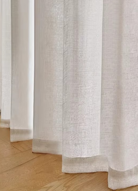 a close up of a curtain with a chair in the background