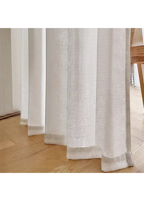 a close up of a curtain with a chair in the background