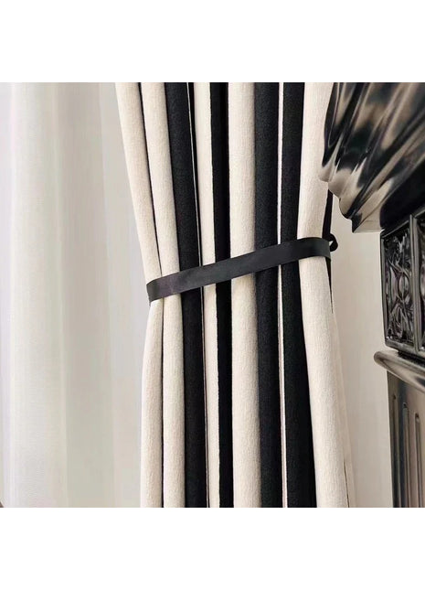 a black and white curtain with a black ribbon