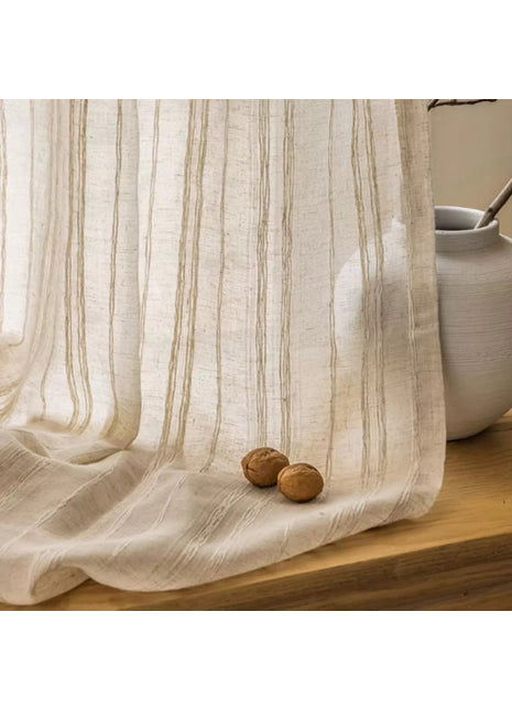 a white curtain with two nuts on a wooden table