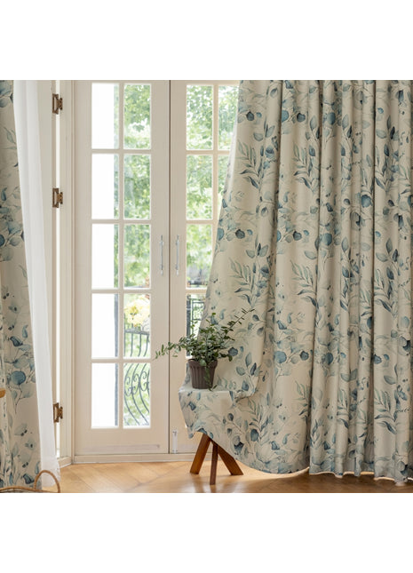 a chair sitting in front of a window covered in curtains