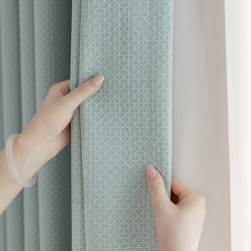 a person holding a curtain with their hand