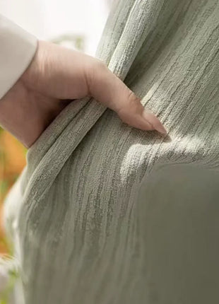 Main tenant le rideau vert chenille pour montrer le relief du tissage