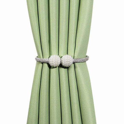 Un ensemble de rideaux verts ornés de perles blanches, mettant en valeur l'élégance des décorations intérieures.