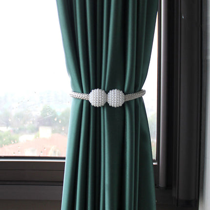 Rideau vert avec deux boules blanches, ajoutant une touche décorative à l'intérieur. Idéal sur Rideaux Déco.